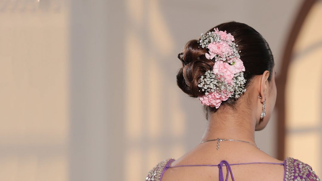 Floral arrangement around a bun, used as accessory-placement inspiration; starting hair length is unknown.