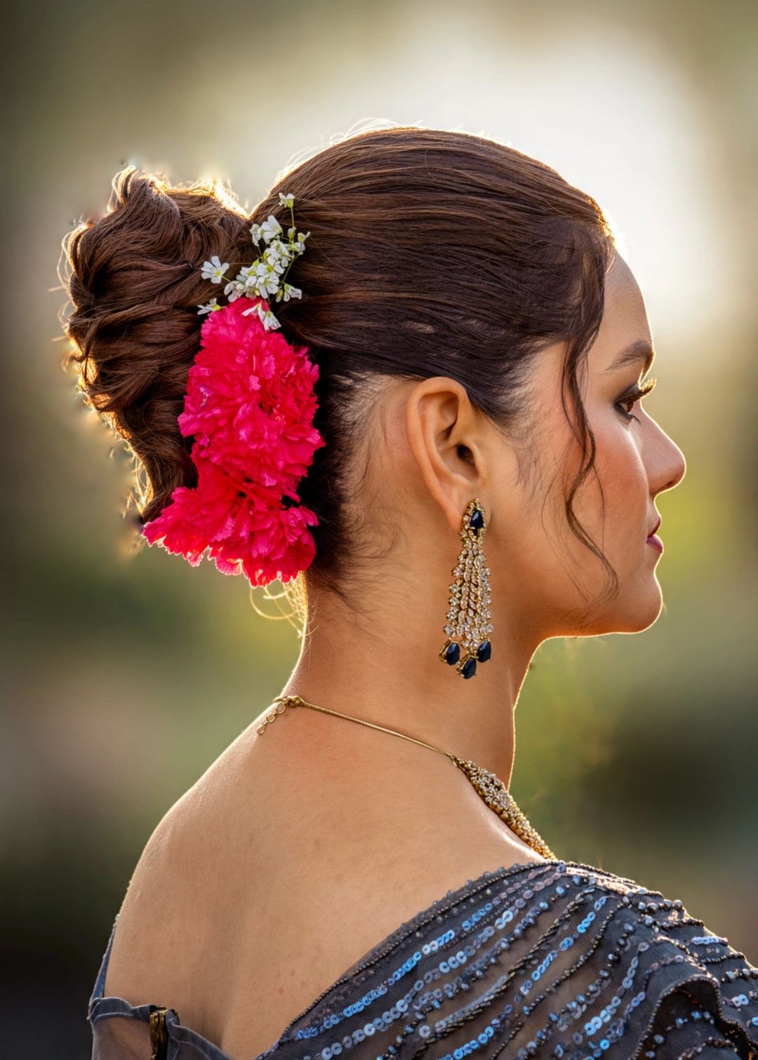 Side view of a pinned updo with pink flowers, illustrating accessory placement.
